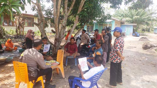 Laksanakan Cooling System, Bhabinkamtibmas Sebarkan Brosur Himbauan Pilkada 2024 Sukses dan Aman