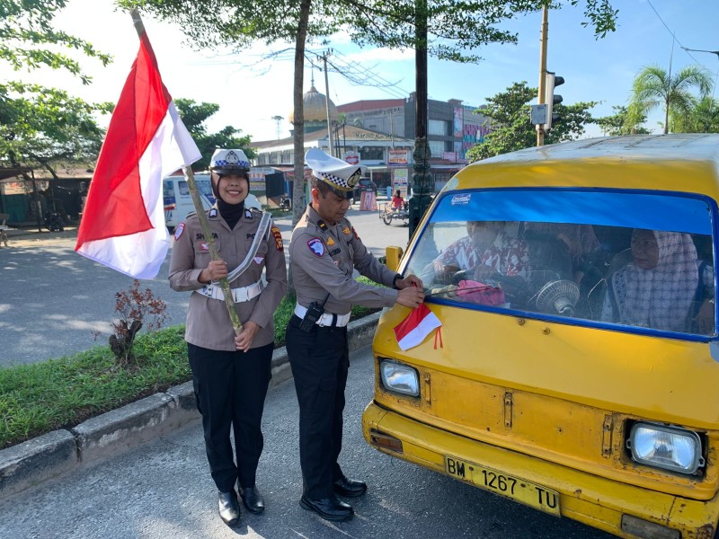 Sambut Hari Kemerdekaan Ke-80, Satlantas Polresta Pekanbaru Bagi Bendera ke Pengendara.